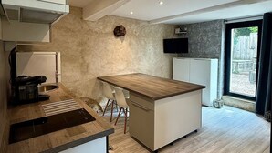 Una cocina moderna con encimera de madera, una isla integrada y una zona de comedor con sillas.