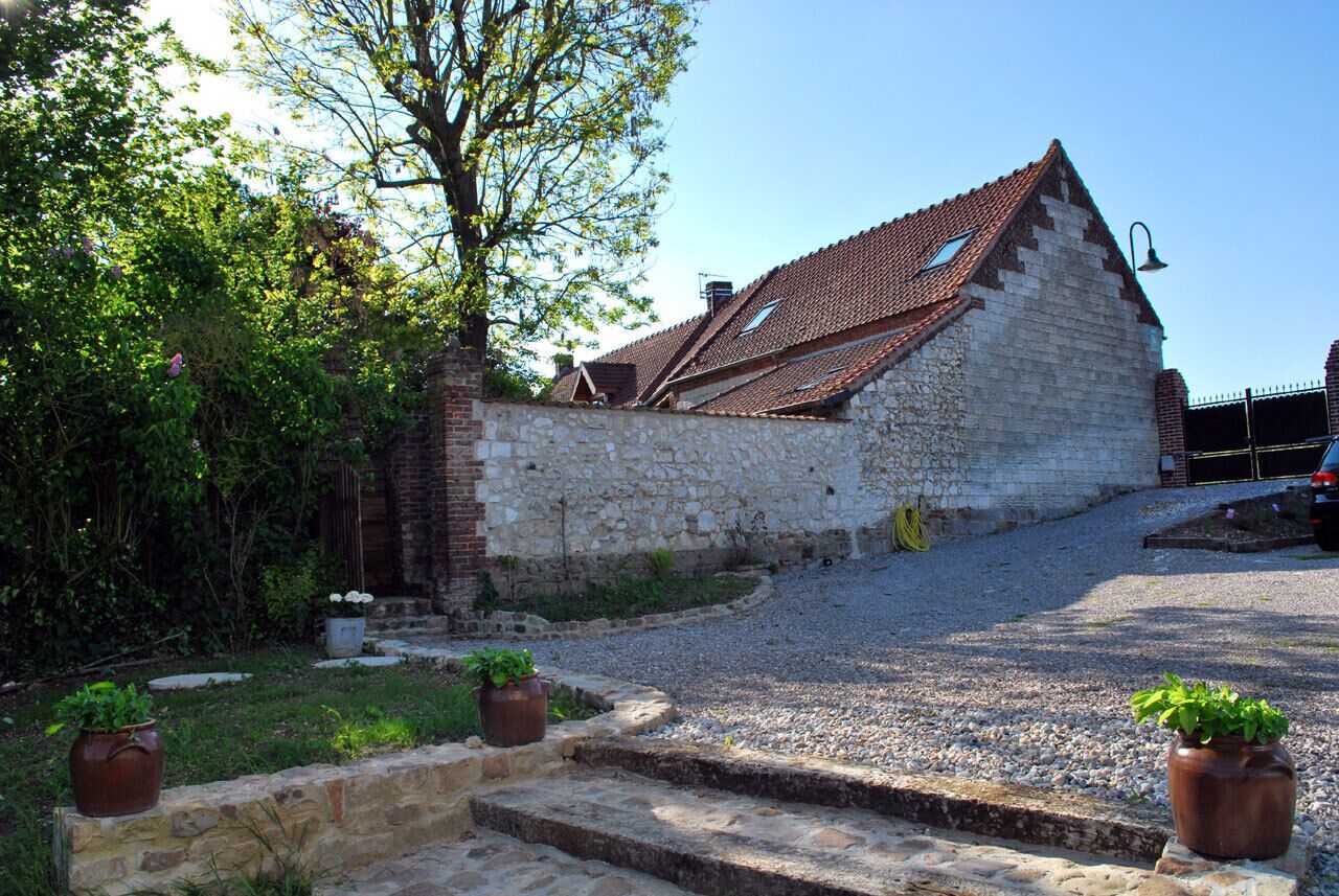 A stone building with a sloped roof, a small window, and steps leading up to the entrance.