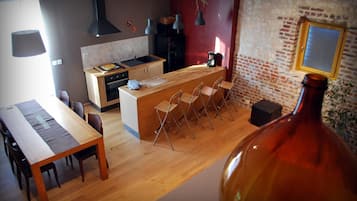Une cuisine moderne avec un îlot central en bois, des tabourets de bar et une grande fenêtre.
