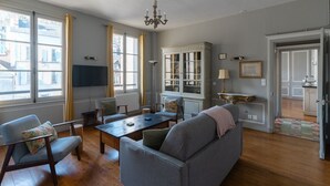 Una sala de estar con sofá, sillas, una mesita de centro y un aparador.