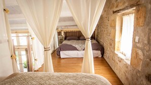 A bedroom with a bed, curtains, a nightstand, and a window. - Gîte "Ile de Ré" with shared 7x7m swimming pool, 20 minutes from the beach (Saint-Coutant-Le-Grand)