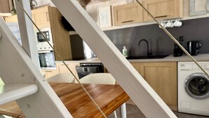 A kitchen with wooden cabinets, a sink, and a washing machine. - Gîte "Ile de Ré" with shared 7x7m swimming pool, 20 minutes from the beach (Saint-Coutant-Le-Grand)