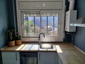 Una cocina con ventana, un lavaplatos y un lavavajillas.
