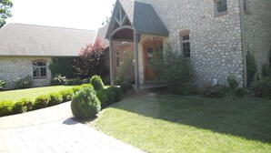 A stone building with a covered entrance and a brick pathway leading to it.