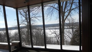 A room with large windows offering a view of a snowy landscape and trees.