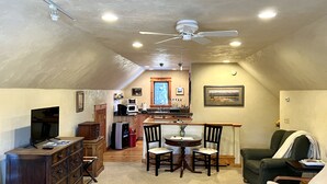 A cozy attic living space with a dining area, kitchen, and seating area. - Mountain View Studio (Bigfork)