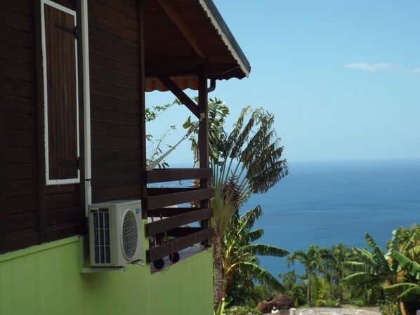 A wooden building with a balcony overlooking the ocean.