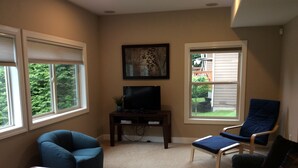 A living room with a television, two chairs, a coffee table, and large windows with blinds. - Spacious house, easy access from Seatac, Seattle & Bellevue.   (Newcastle)