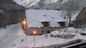 A snow-covered mountain village with stone buildings and a snow-covered road.