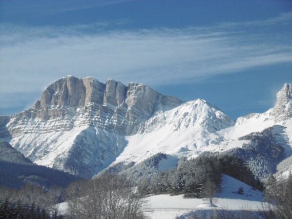 A mountainous landscape with snow-covered peaks and a clear sky.