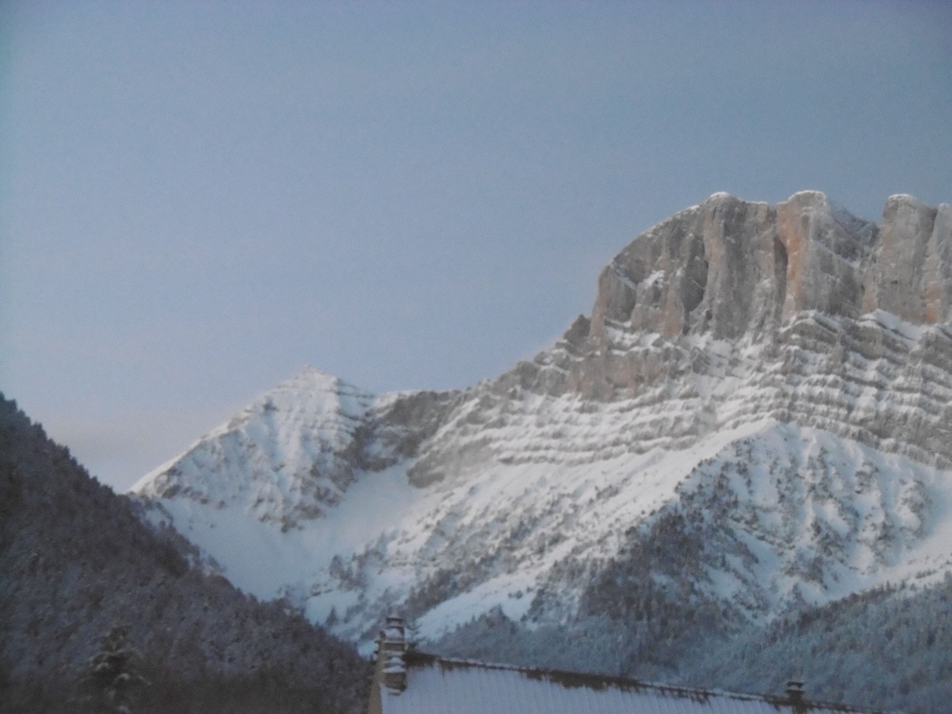 A snow-covered mountain with a clear sky.