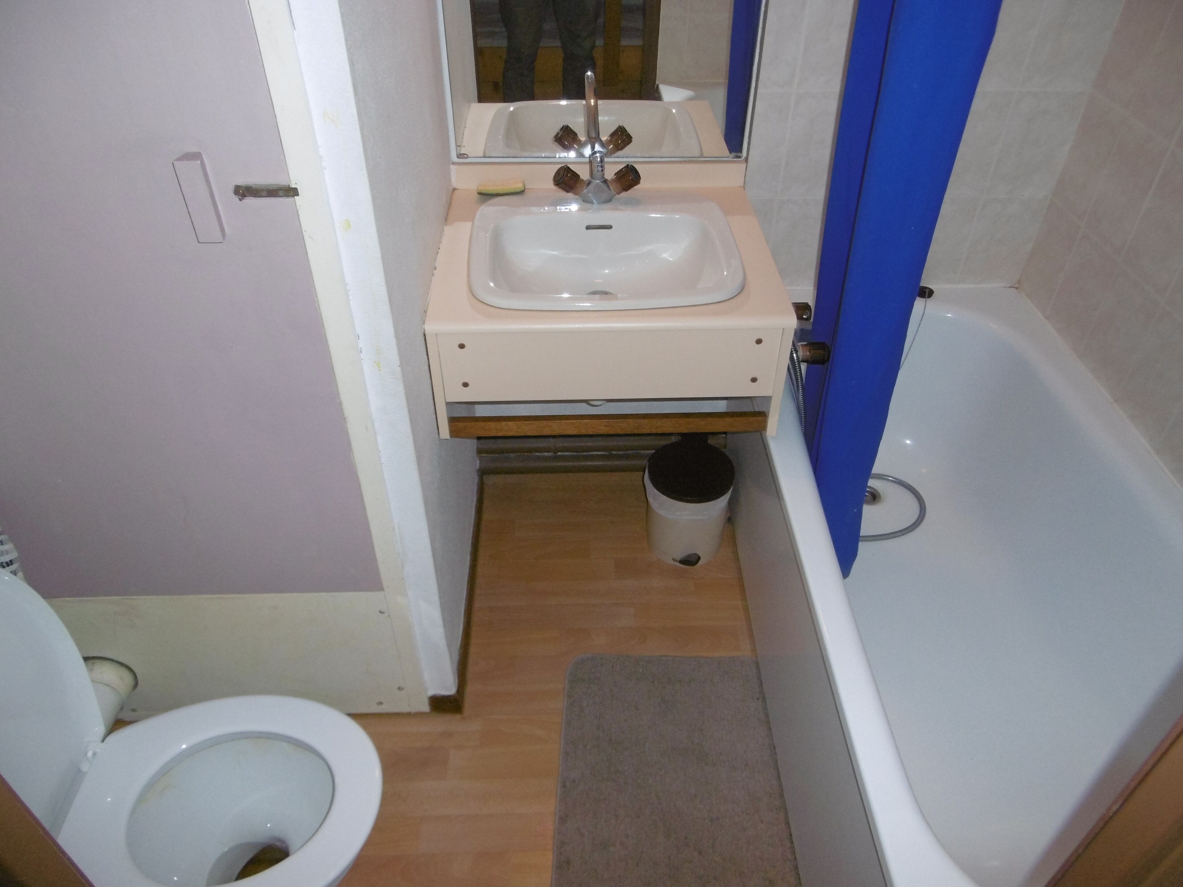 A small bathroom with a toilet, sink, and bathtub.