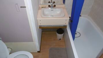 A small bathroom with a toilet, sink, and bathtub.