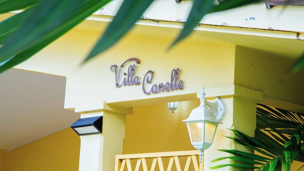 Un edificio amarillo con un cartel que dice "Villa Carelle".