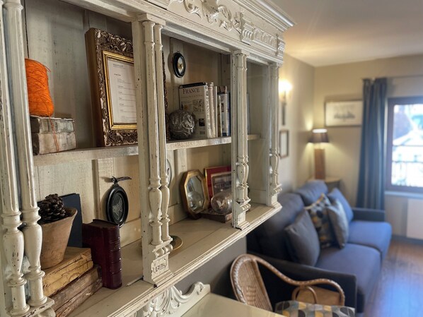 A living room with a white ornate shelf, a blue sofa, and a window with curtains. - CHARMING APARTMENT FOR 4 PEOPLE. HISTORIC DOWNTOWN. BRIGHT. PARKING AVAILABLE (Honfleur)