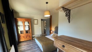 Ein Schlafzimmer mit einem Bett, einem Holzschrank, einem Kleiderschrank und einer Hängeleuchte.