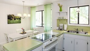 Una cocina con una mesa de comedor, una estufa y un fregadero.