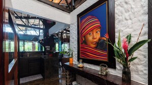 A kitchen with a stone countertop, a vase with flowers, and a framed painting on the wall. - Breakfast With Toucans And Monkeys (San Miguel)