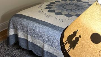 Quarto com cama, quadro, televisão e porta.