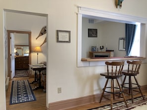 A room with a wooden desk, two wooden chairs, a mirror, a framed certificate on the wall, and a patterned rug on the floor. - Adults Only, King One Bedroom, Converted 1894 Historic Hotel,Downtown Buffalo Wy (Buffalo)