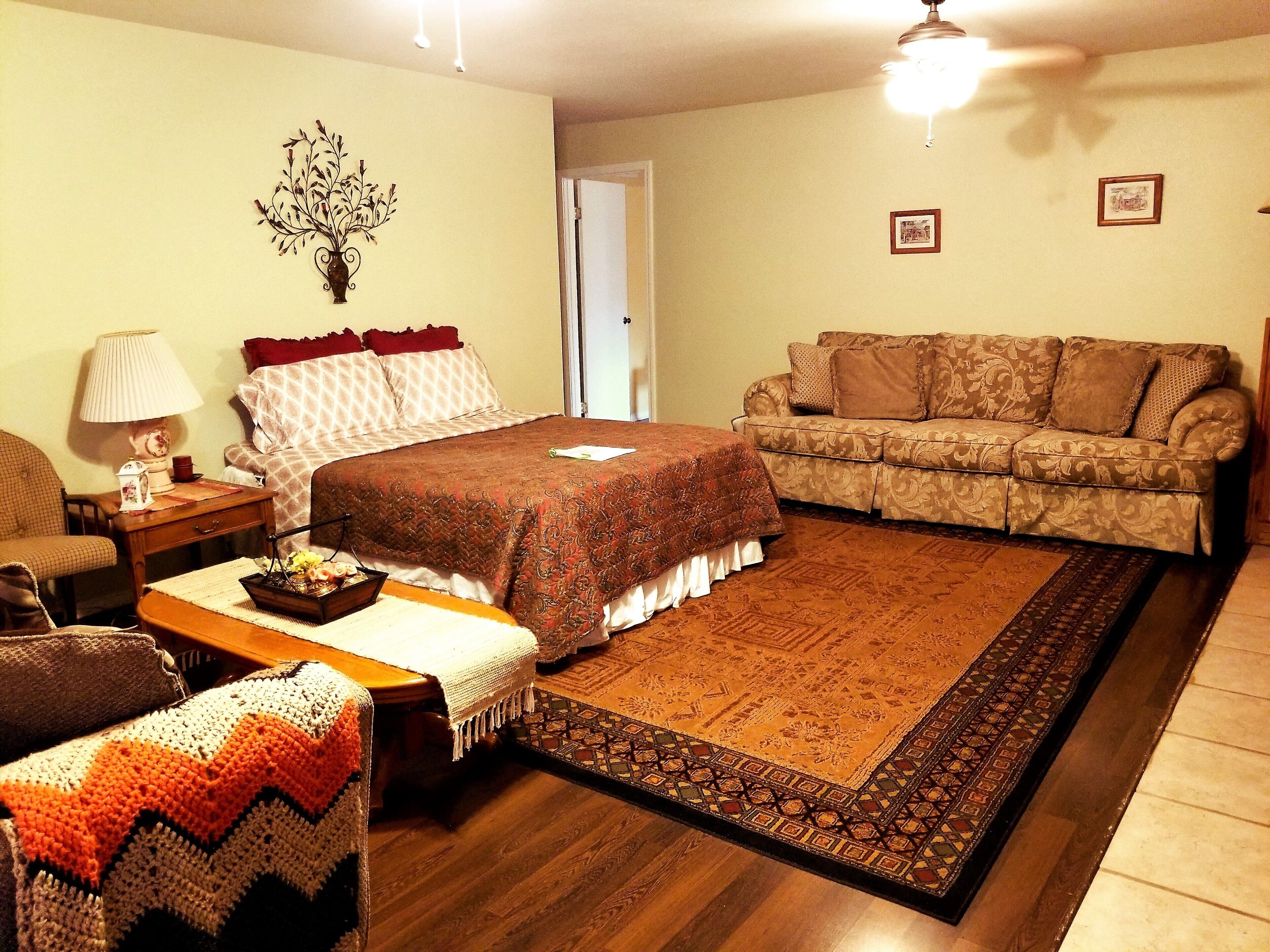 Una sala de estar acogedora con una cama grande, un sofá, una mesa de centro y una chimenea.