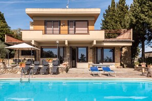 A two-story house with a swimming pool, outdoor seating, and a stone facade. - Modern Panoramic Villa with swimming pool in Florence - Tuscany (Firenze)