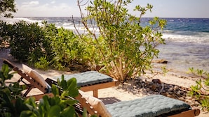 A beachside lounge area with wooden loungers and a view of the ocean. - Green Lodge Moorea (Moorea-Maiao)