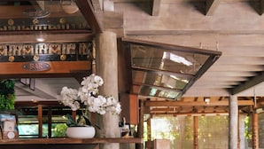 A wooden bar area with a billiards table, chairs, and a potted plant. - Green Lodge Moorea (Moorea-Maiao)