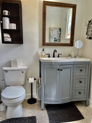 Een bad/douchecombinatie, een haardroger, handdoeken, zeep