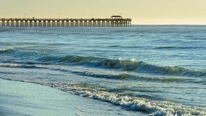 A pier extending into the ocean with waves crashing onto the shore. -  Special Exceptional Offer Guaranteed Oceanfront Villa  Available July 11-18 (Myrtle Beach)