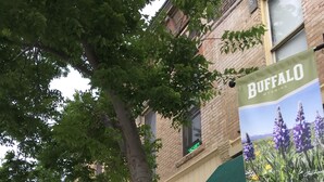 A building with a green awning labeled "Camping" and a sign for "Buffalo, Wyoming." - King One Bedroom, Converted1894 Historic Hotel, Downtown Buffalo Wyoming (Buffalo)