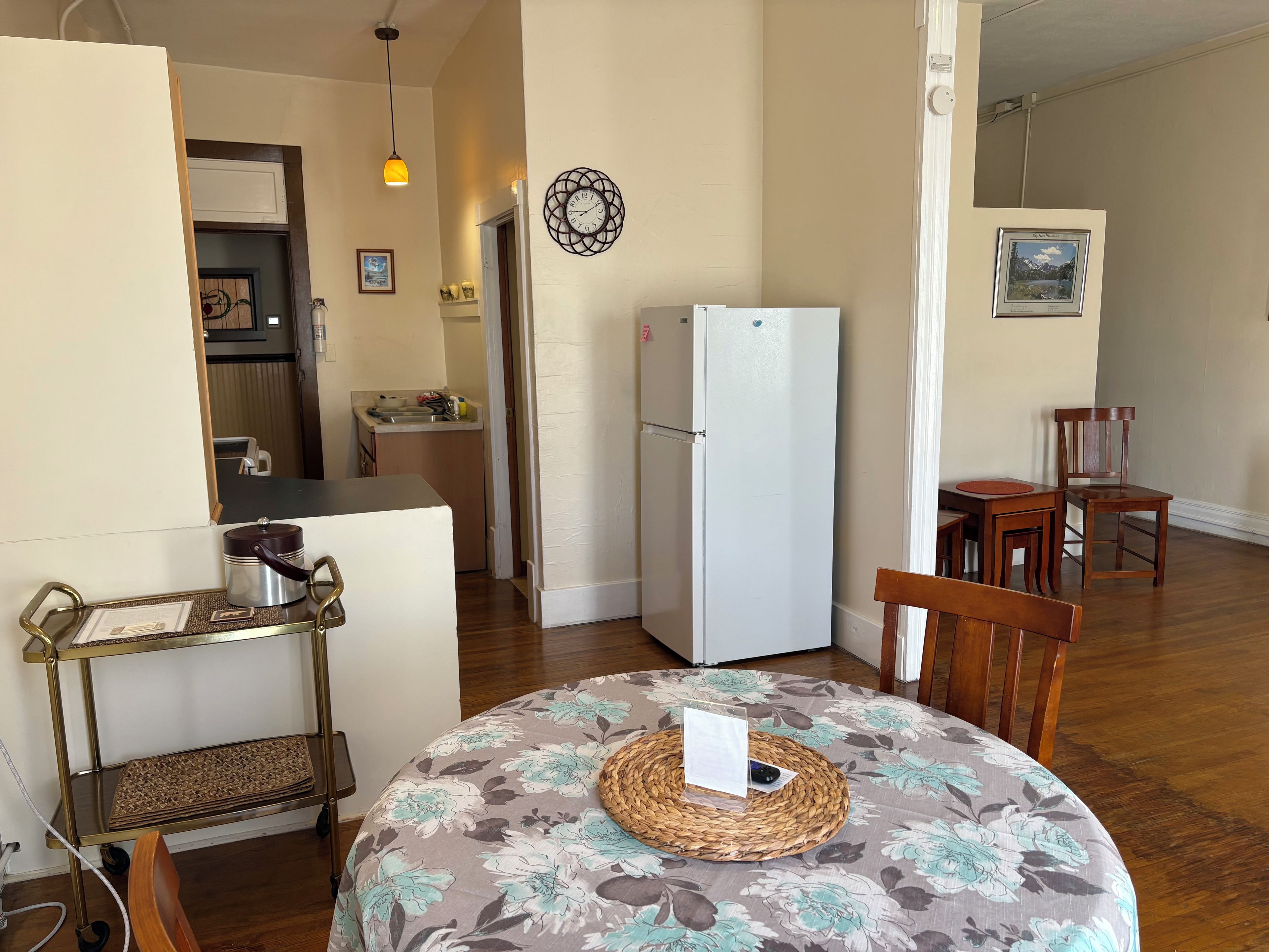 A compact living space with a dining area, kitchen, and a refrigerator.