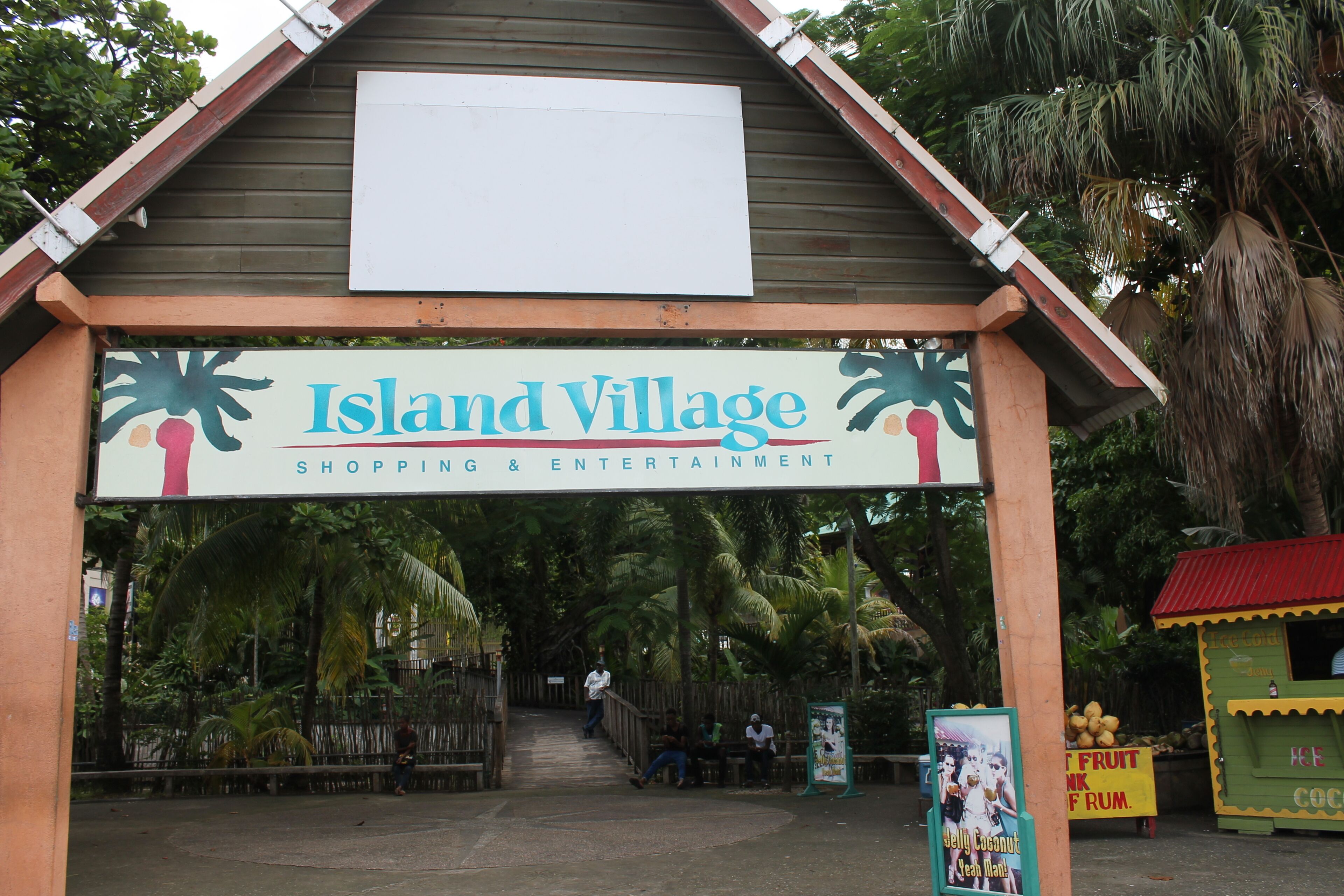 Schild für Island Village im tropischen Stil, mit Palmen und einer Strandansicht.