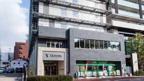 A multi-story hotel with a modern facade, large windows, and a visible entrance with signage.