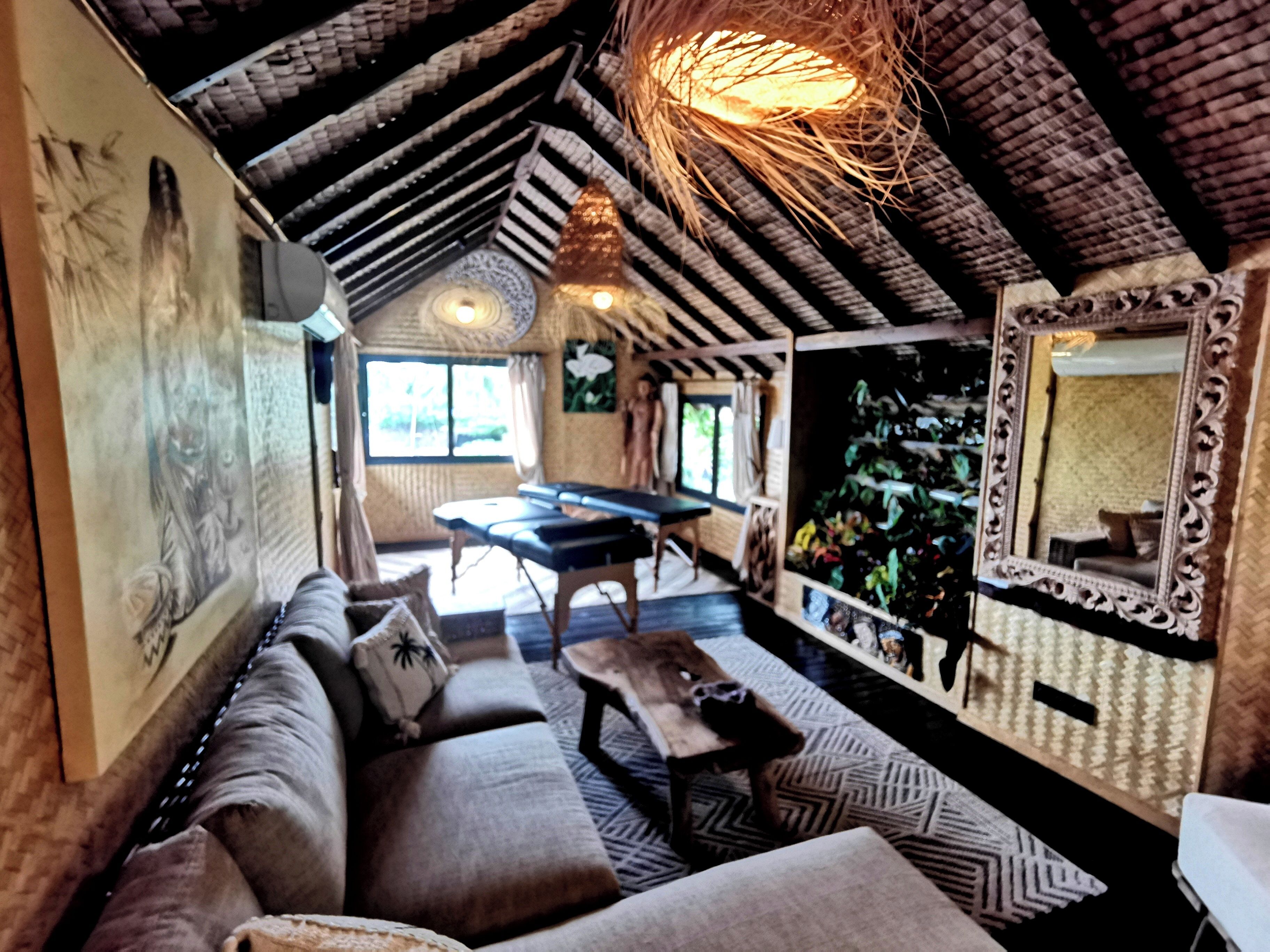 Una habitación acogedora con un sofá, una mesa y un espejo.