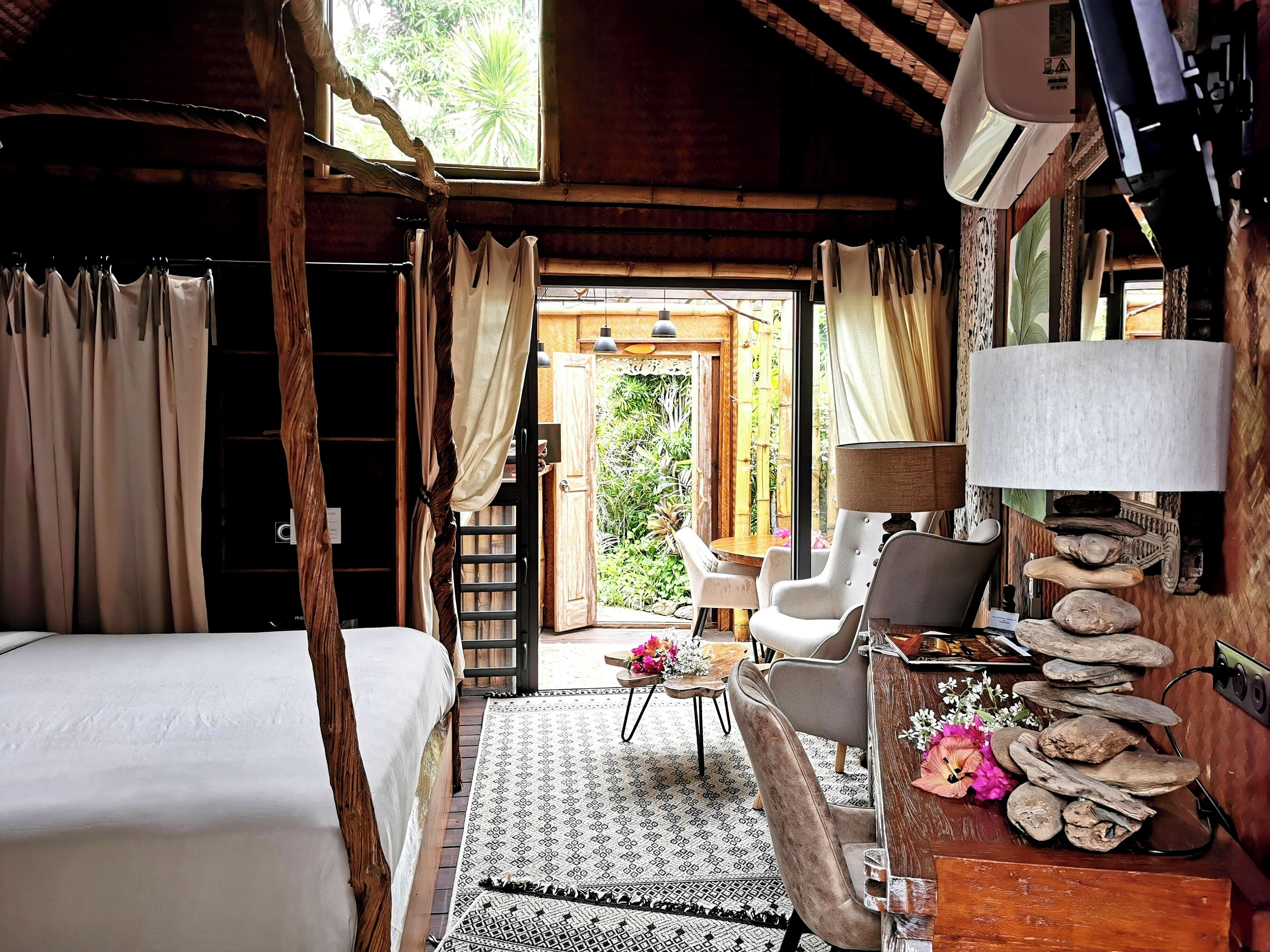 Una habitación acogedora con una cama, un escritorio con lámpara, una silla y vistas al exterior.