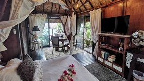 Un dormitorio con cama a dosel, televisión y estantería.