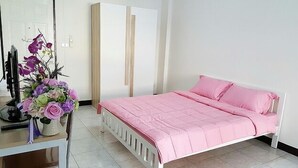 A bedroom with a bed, a desk, and a chair.