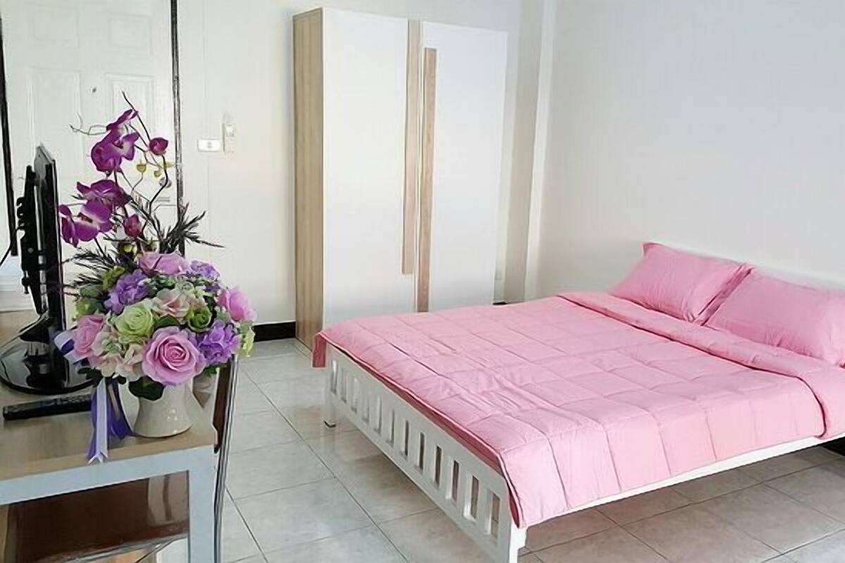 Un dormitorio con cama, escritorio y silla.