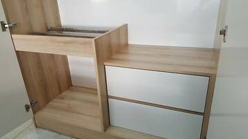 A room with a wooden desk and a white cabinet.