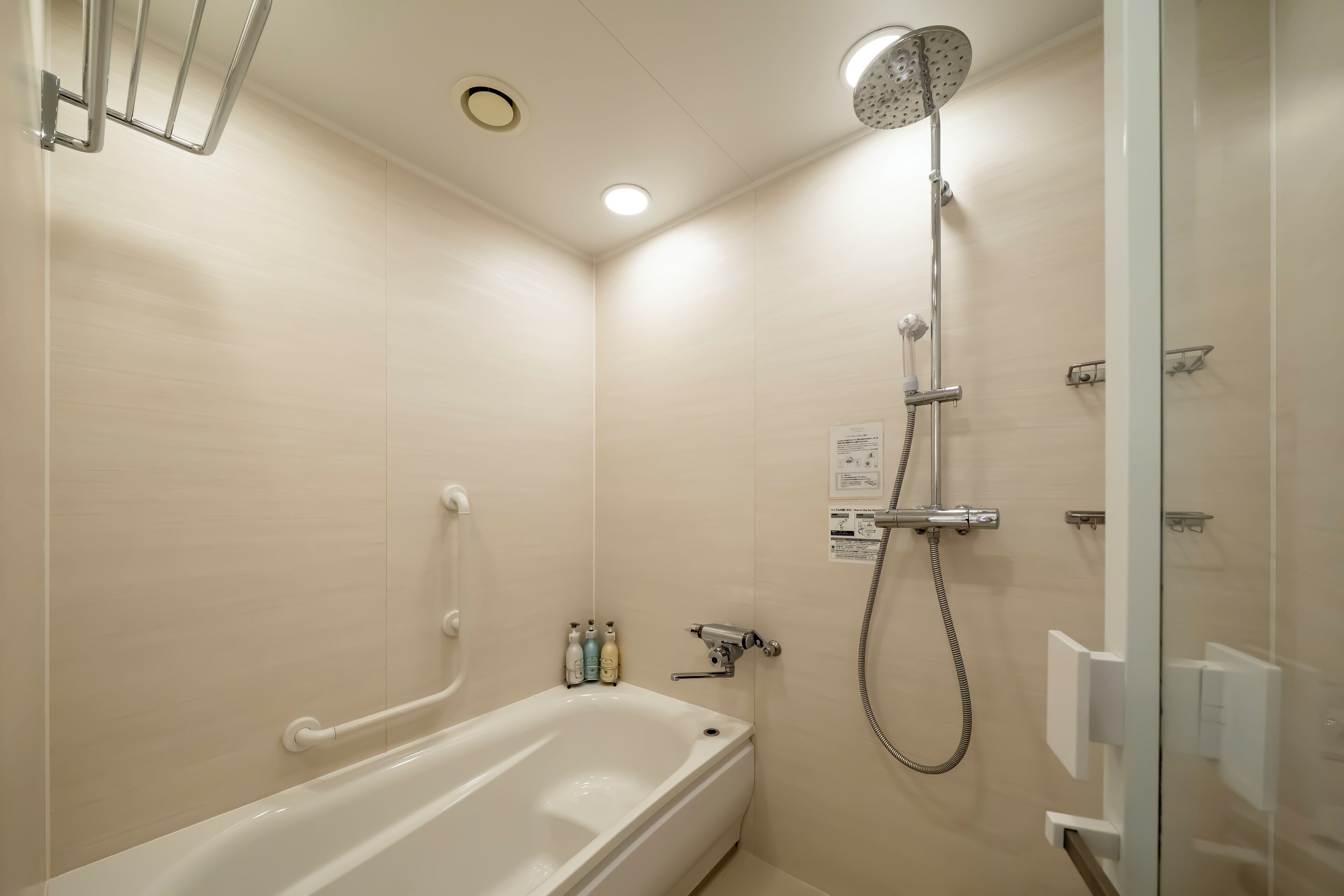 Un baño moderno con bañera, ducha y mampara de vidrio.