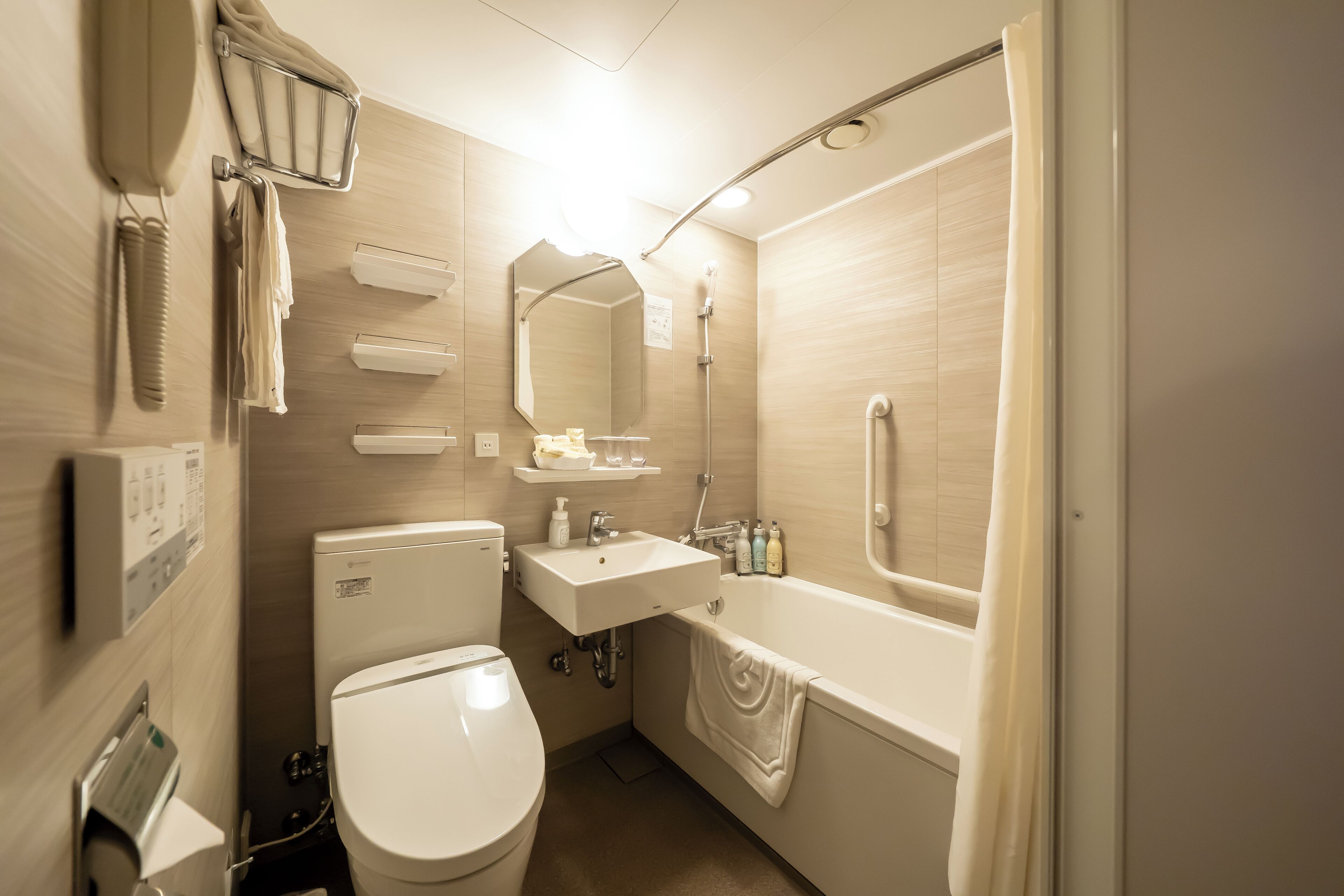 A modern bathroom with a toilet, sink, and bathtub.