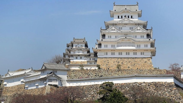 Una estructura al estilo de castillo con varios niveles, arquitectura tradicional y base de piedra.