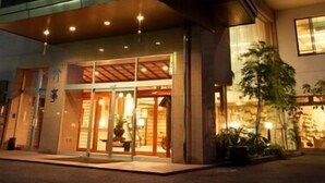 Un hotel de varios pisos con un diseño arquitectónico moderno, que cuenta con una entrada destacada con puertas de vidrio y un vestíbulo cubierto.