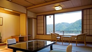 Una habitación tradicional japonesa con suelo de tatami, una mesa baja y sillas.
