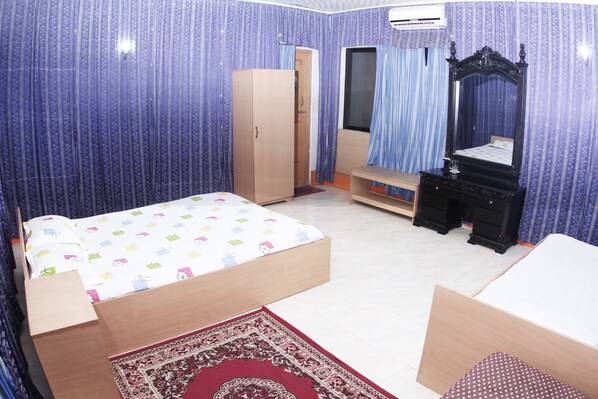 Une chambre à coucher comprenant un lit, une armoire, une commode, un miroir et une fenêtre avec des rideaux.