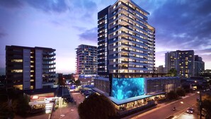 A modern high-rise hotel with multiple floors, large windows, and a prominent digital display on the side. - Alcyone Hotel Residences (Hamilton)