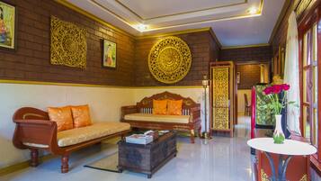 A traditional room with a sofa, a small table, and decorative wall art.