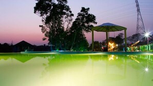 A tranquil outdoor setting with a reflective pool, a gazebo, and trees. - Rangauti Resort (Moulvibazar Sadar)