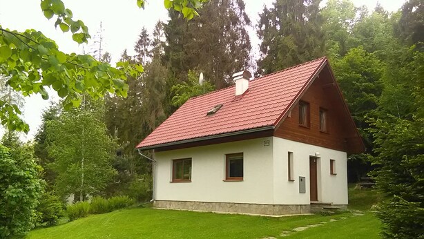 A small, single-story house with a red-tiled roof, white walls, and a small front porch. - Chata Pohoda Slovenský Raj (Spišské Tomášovce)